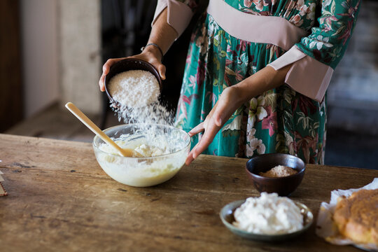 Young woman preparing cake dough, partial view