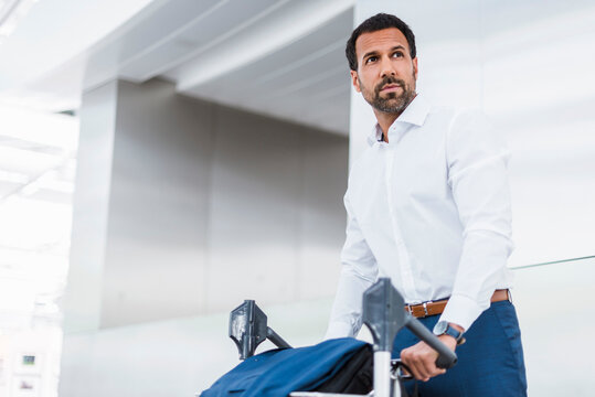 Businessman using baggage cart
