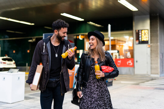 Laughing young couple with purchases in the city