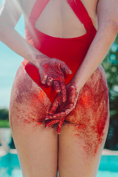 Rear view of woman wearing red swimsuit with bottom covered with red sand