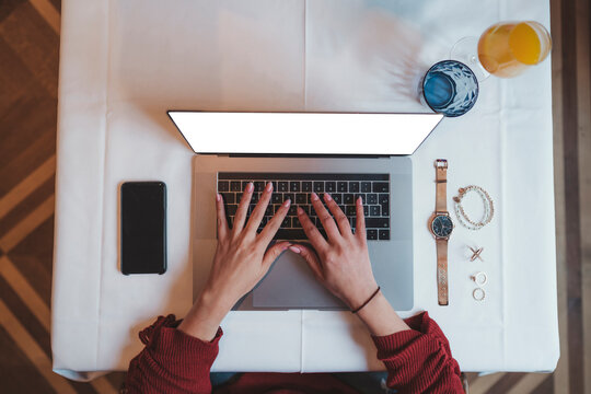 Top view of woman using laptop on table in a cafe