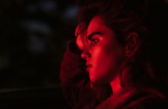 Close-up of thoughtful woman looking away while sitting in car at sunset