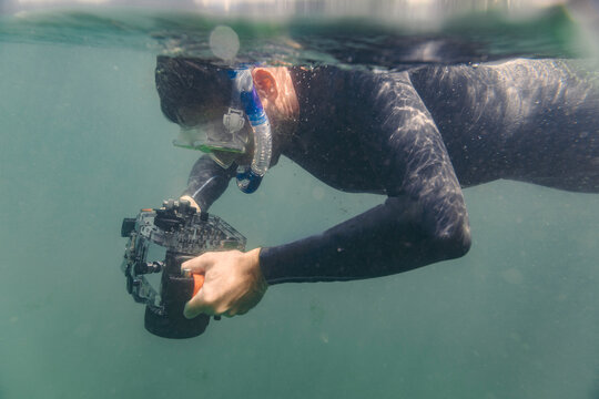 Man diving with underwater DSLR camera case