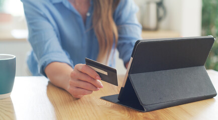 Fototapeta premium Tablet, hands or woman with credit card in home for bills payment, budget or internet banking. Debit, house or person with digital money, savings or financial investment with tech for online shopping