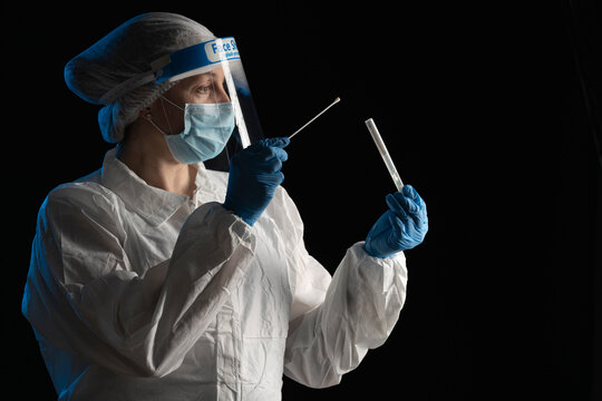 Woman in protective wear putting a swab into a tube