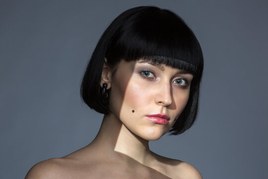 Portrait of young woman with cheek piercing