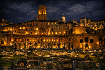 Fototapeta premium Historic Roman ruins illuminated at night with warm lights highlighting ancient architecture and archaeological structures under a dramatic dark sky, creating a powerful historical and travel scene.