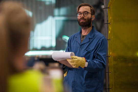 Man with clipboard in factory