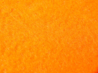 A high-resolution macro close-up showcasing the vibrant orange texture of a felt or fleece fabric © Mohd Azrin