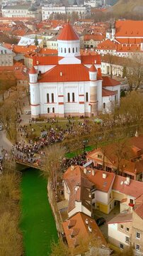 Aerial vertical view of hundreds of people enjoying festivities and celebrating St. Patrick's day in Vilnius. Vilnele river was dyed green to mark the patron saint of Ireland's day.