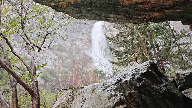 Mountain Waterfall Beneath Natural Rock Overhang