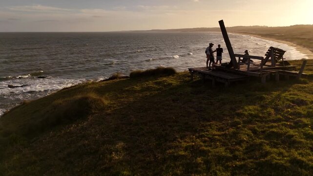 Tourists stand at the Cerro Chato viewpoint in Santa Teresa Park, overlooking Playa del Barco beach and the Atlantic Ocean.
