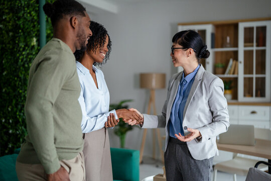 Real estate agent shaking hands with diverse couple