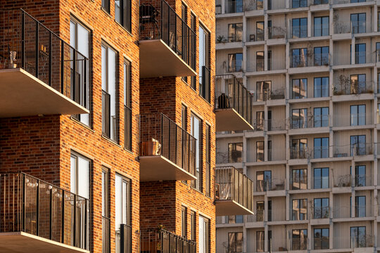 Sunlight on Copenhagen apartment building with modern residential balconies and brick facade showing architecture warmth for real estate and housing market