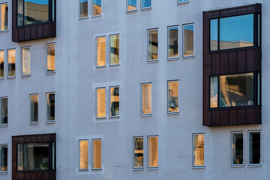 Urban Copenhagen building facade with modern apartment windows forming architectural pattern and residential geometry for housing and real estate marketing
