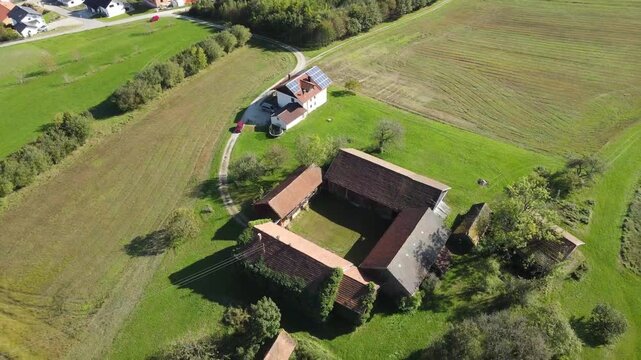 Traditional Bavarian four sided farm courtyard with barns and farmhouse surrounded by agricultural fields in Lower Bavaria countryside Germany