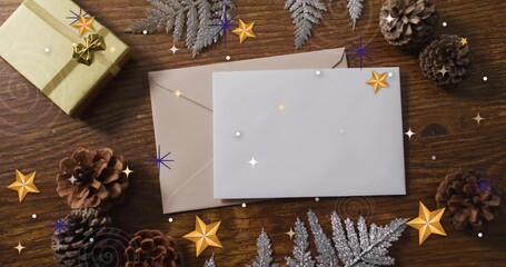 Showing blank white card over brown envelope on dark wood, with pinecones, gold gift, silver fern © vectorfusionart