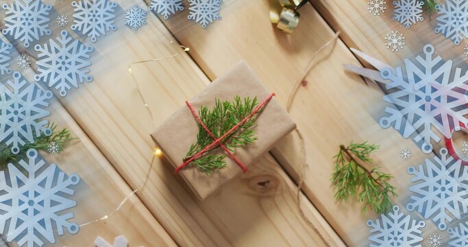 Displaying kraft-wrapped gift box tied with red twine on wood plank, showing craft tools and decor