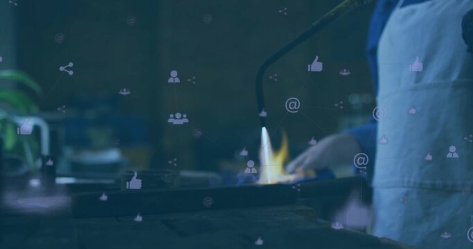 Chef white-apron blue-shirt torching pan with hand-torch flame in kitchen, social icons, copy space