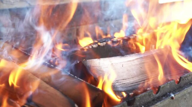 Flame wood in bonfire. Camp barbecue wood charcoal burns in the grill. Blaze fire flame texture background. Tongues of flame. burning wooden logs and large orange flame. Glowing Firewood campfire