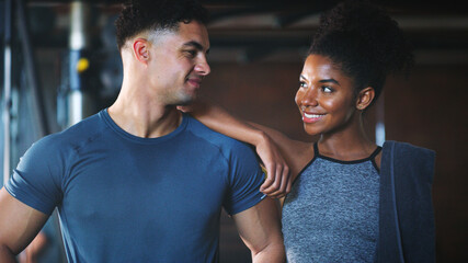 Fototapeta premium Happy, couple and break in gym, fitness and confident for exercise routine and training for wellness. Athlete, partnership and interracial people with smile after workout and rest in health club