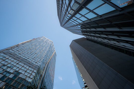 Modern glass skyscraper architecture with multiple towers in Frankfurt Germany finance center captured in clear daylight for corporate skyline concept