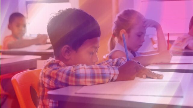 Boy writing at desk in school, pencil touching paper causing shifting purple flare during classwork