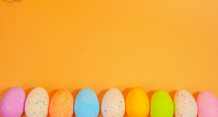 Colourful Easter eggs lined up on a yellow background