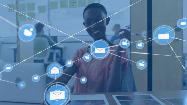 Woman at laptop watching blue envelope appearing, engaging with expanding icon network for business