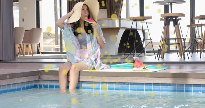 Woman sitting pool edge glancing phone fixing hat eating melon resting home bokeh drifting over her