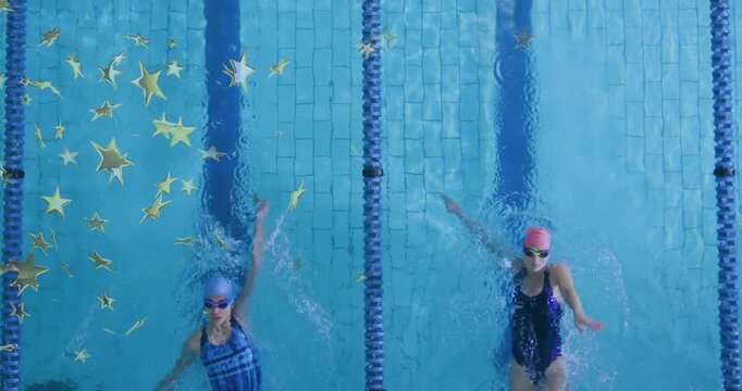 Two female swimmers swimming backstroke after arm entering frame, training while moving gold stars