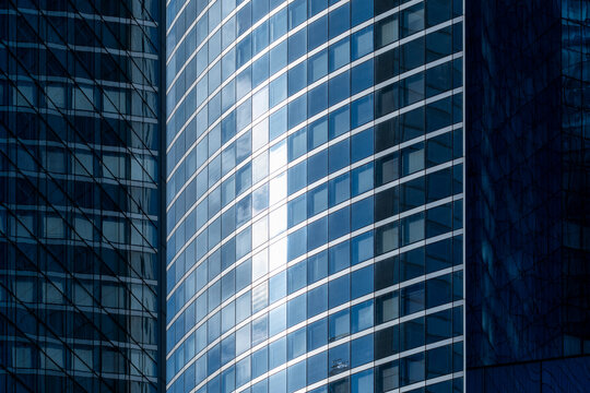 Curved blue glass facade texture with linear bands shapes a modern corporate skyscraper detail for contemporary highrise business architecture background