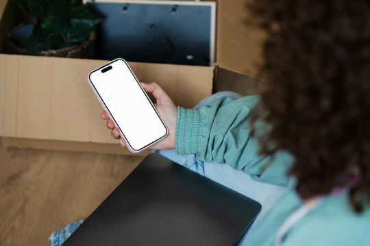 Woman using smartphone with blank screen at home for communication