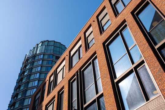 Modern architecture building facade exterior with windows in urban sky featuring brick and glass corner design and structure for mixed city blocks