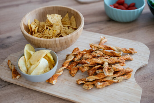 Assorted savory snacks on wooden board for evening friendship gathering