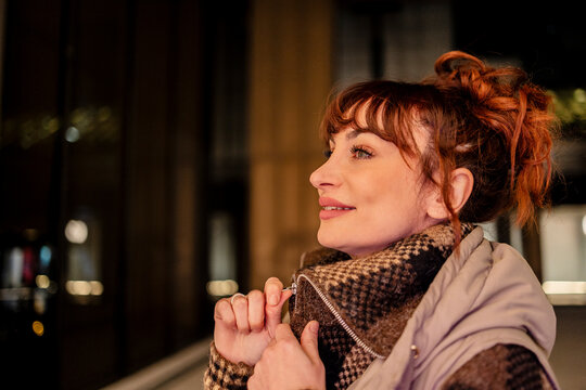 Smiling woman with messy bun zipping jacket