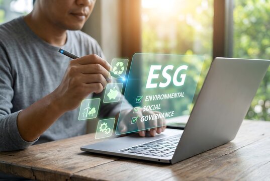 Person uses a laptop to interact with a holographic interface displaying esg icons for environmental and social governance.