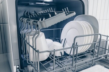 Efficient Dishwashing: A Modern Tabletop Dishwasher Loaded with Clean Plates and Cups Ready for Use