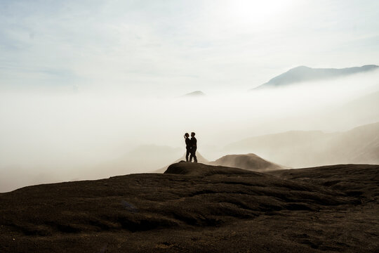 Romantic couple embracing on misty volcanic landscape in Java Indonesia