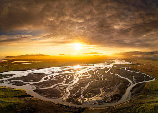 Aerial view of glacial braided river and volcanic sands at sunset in Iceland