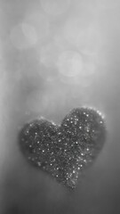 Fototapeta premium Glittering heart in grayscale bokeh.