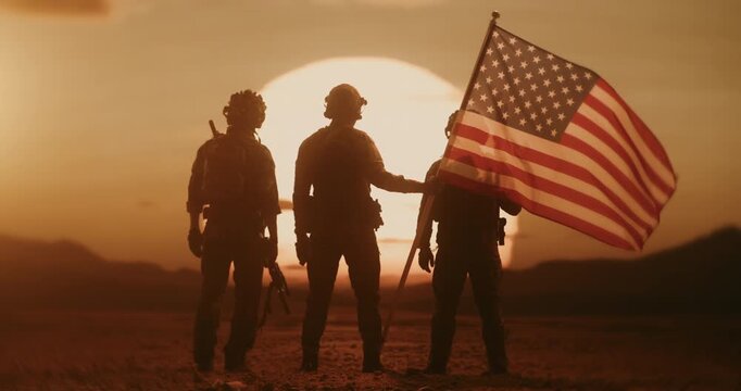 Brave US Soldiers Hold the American Flag with Glorious Desert Sunset in Background. Silhouettes of War Veteranms Glowing in Golden Hour as They Stand Watch on a Heroic Peace Mission Defending Freedom 