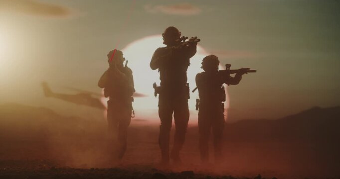 Three Male Soldiers in Advanced Combat Gear March Across a Desert Warzone, Silhouette by a Massive Air Force Formation of Helicopters. Patrol With Rifles, Helmets,  Modern Military Battlefield