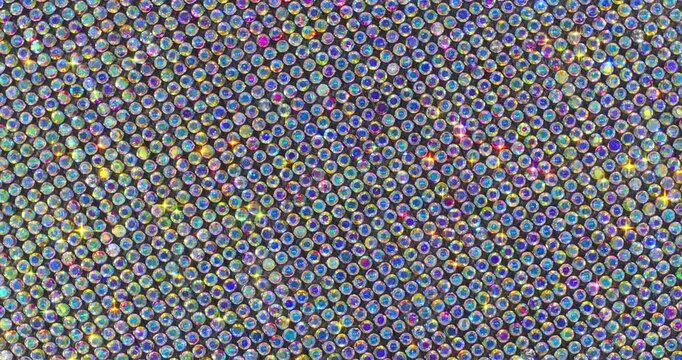 Rotating Sparkling Crystals with Star Flares. Macro video of faceted rhinestones with intense blue star flares and smooth rotational camera movement on dark surface.