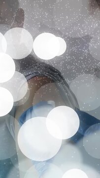 Vertical video: Nurse swabbing, inserting syringe into senior arm, giving jab with bokeh obscuring