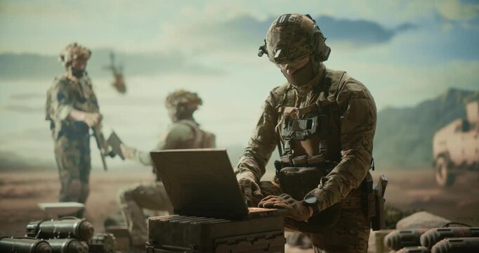 Soldiers on Desert Command Base, Using Laptop for LSR Analysis, Target Tracking, Battlefield Networking, Strike Coordination as Teammates Secure Munitions and Reconnaissance on Modern Military Mission