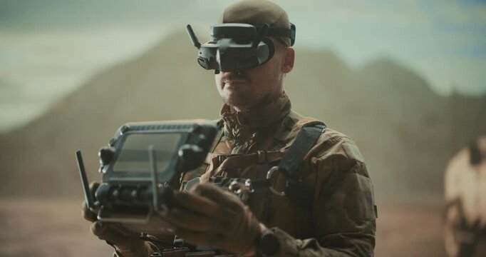 Portrait Army Soldier Uses FPV Goggles and Controller to Pilot an AI Tactical Drone to Precision Strike Targets, Enemy Scouting, Force Protection During a High-tech Middle East Desert Mission.