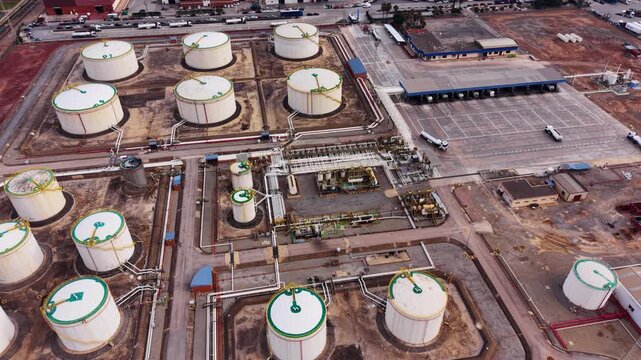 Aerial view of a petroleum storage tank farm with interconnected pipelines, pumping units and truck loading terminal used for bulk fuel storage and distribution in an industrial energy facility