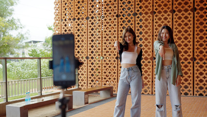 Gen z vlogger influencer asia teen girl trending relax smile moving dance at city park street...