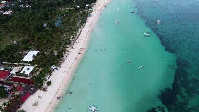 Cinematic drone aerial perspective of the pristine turquoise waters and white sand beach of Bantayan Island, Philippines